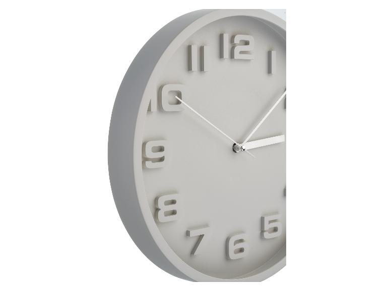 Ronde grijze wandklok met reliëfcijfers.