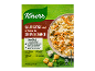 Verpakking kaassausbasis, met pasta en kaasstukjes op een bord.