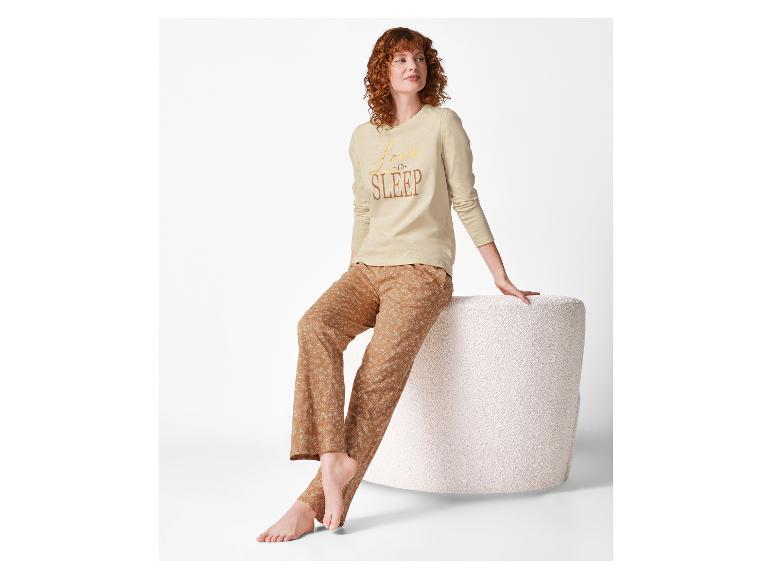 Vrouw in beige pyjamatop met lange mouwen en pyjamabroek met bloemenprint