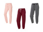 Drie joggingbroeken in roze, rood en grijs.