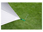 Een witte tent met groene bandjes bevestigd aan een metalen pin in het gras.