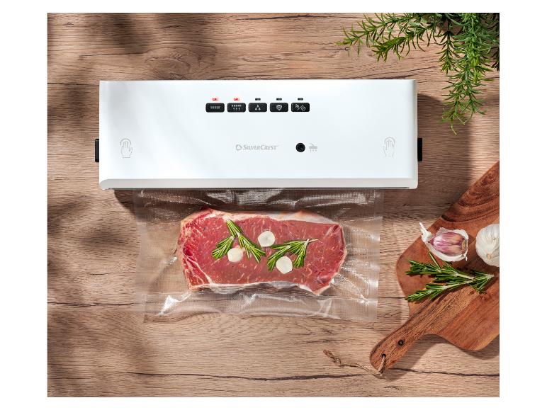 SilverCrest vacuümsealer met biefstuk, rozemarijn en knoflook op een houten tafel.