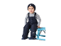 Jongen in donkerblauwe overall en gebreide muts zit op een blauwe bank.