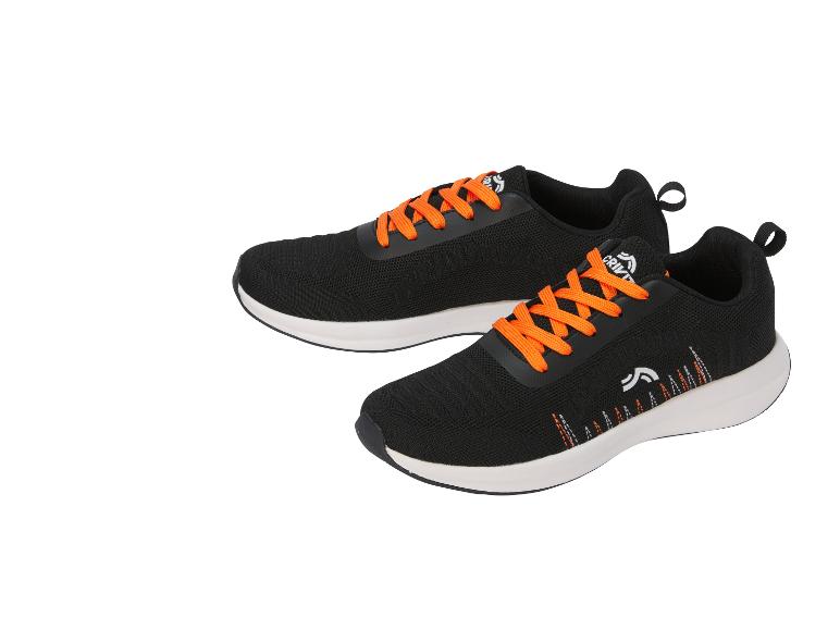 Een paar zwarte sportschoenen met oranje veters en decoratieve details.