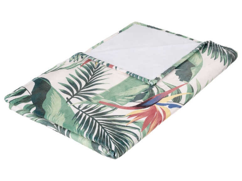 Een gevouwen dekbed met tropische print.