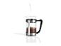 Een stalen french press met koffie en water dat wordt gegoten.
