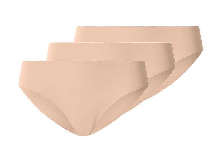 Set van drie naadloze beige damesonderbroeken, diagonaal gerangschikt.