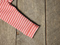 Een roze gestreept kledingstuk op een houten achtergrond.