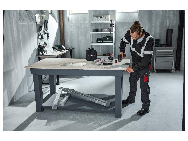Man in PARKSIDE PERFORMANCE® waarschuwingssweatjack boort in een werkplaats.
