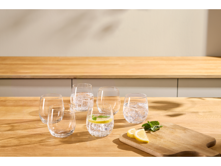 Glazen water met citroen en munt op een houten aanrecht.