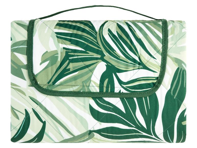 Gepatroneerde picknickdeken met groen tropisch bladmotief.