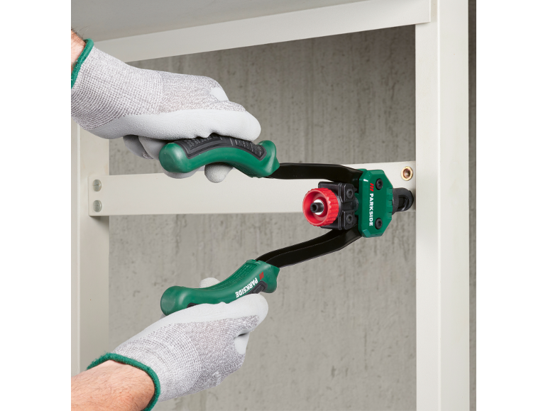 Werkhandschoenen en Parkside nietpistool in gebruik.