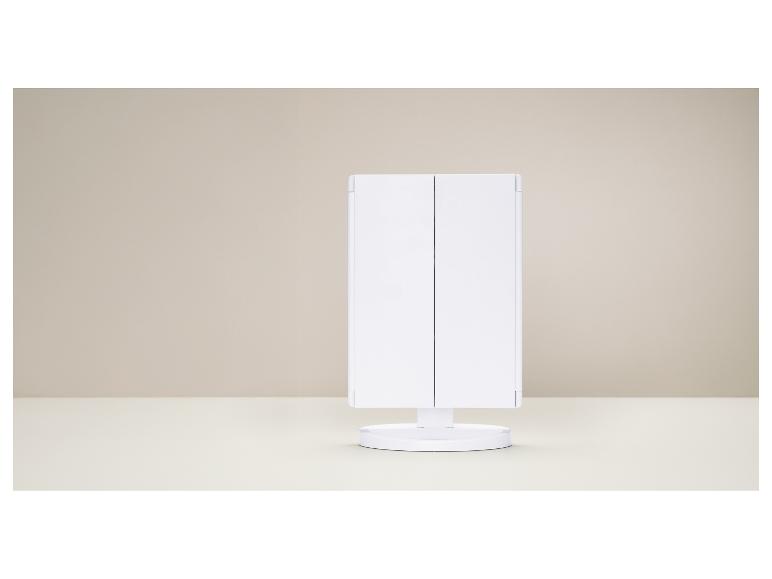 Wit driedelig make-upspiegel op een tafel