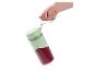 Hand houdt een mintgroene Silvercrest draagbare blender met rode smoothie vast.