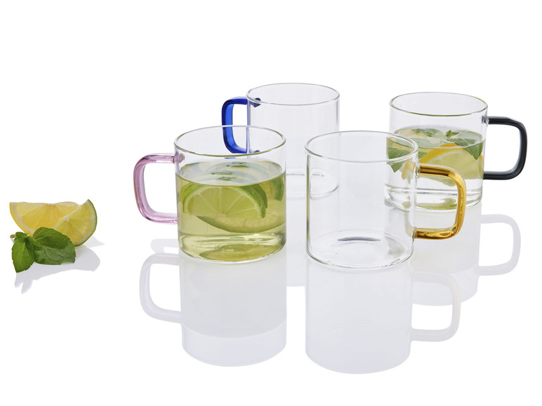 Glazen bekers met gekleurde handvatten, gevuld met thee en citroen