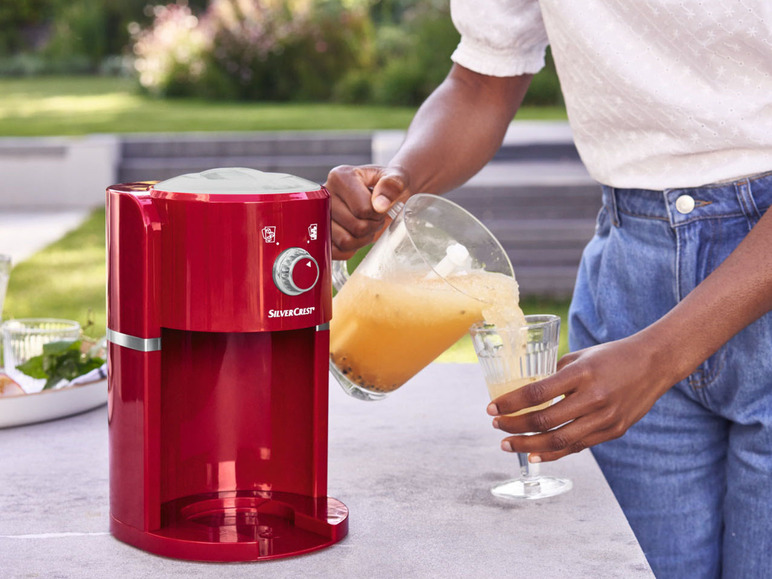 Een rode SilverCrest ijsmachine maakt ijs voor een glas limonade.