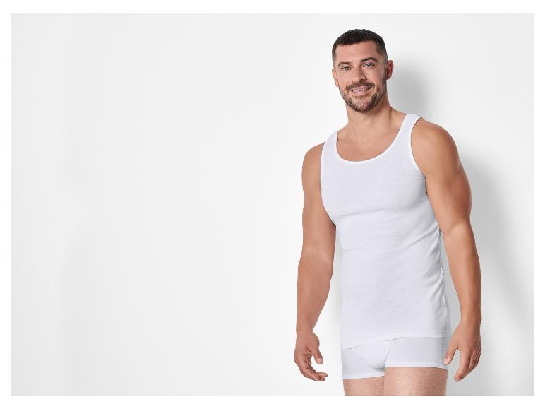 Man draagt een witte onderhemd en witte onderbroek.