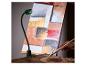 LED-werklamp met flexibele arm verlicht abstract schilderij, met hand die penseel en palet vasthoudt.