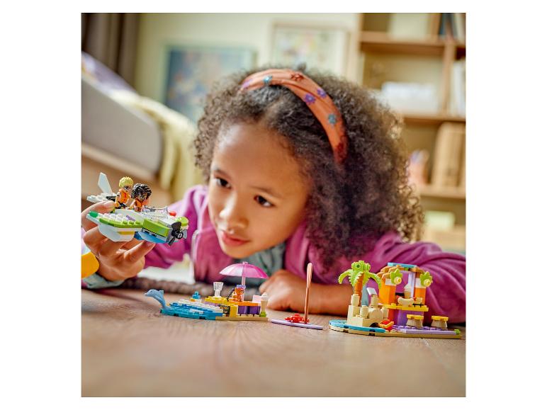 Meisje speelt met LEGO Friends sets op de vloer.