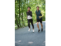 Twee hardlopers in sportkleding joggen buiten, vrouw in een jas en man in een vest.