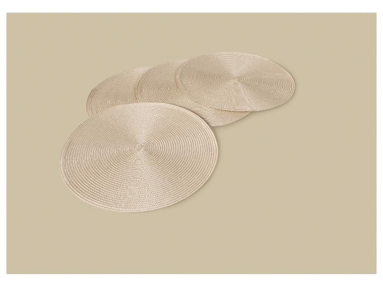 Vier ronde beige onderzetters gerangschikt op een beige ondergrond.