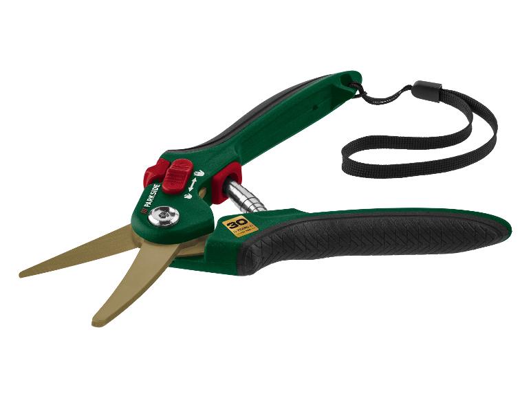Groene en zwarte grasschaar met gouden bladen en een zwarte polsband.