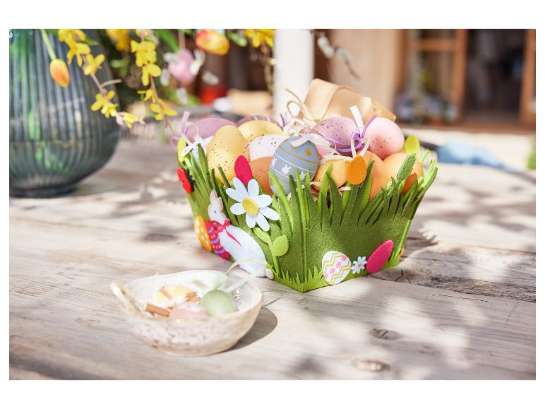 Een paasmand gevuld met eieren en versierd met paasmotieven.