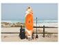 Oranje en wit SUP-board met accessoires op een zandstrand aan zee.