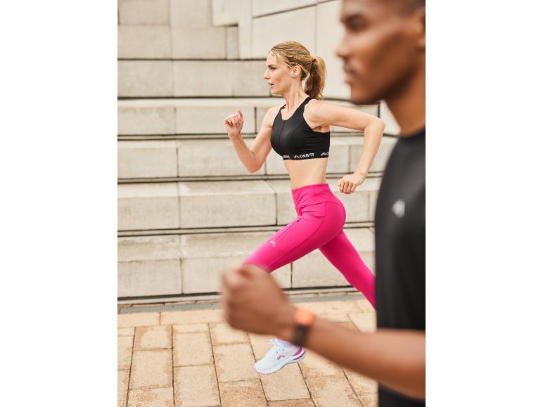 Vrouw joggend in roze leggings en zwarte Crivit sportbeha.