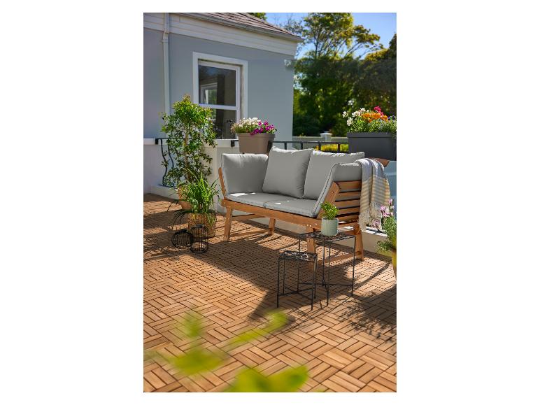 Houten bank met kussens op een terras met houten vloer en bloempotten.