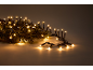 Kerstverlichting met warmwitte LED-lampjes en groene dennentakken.