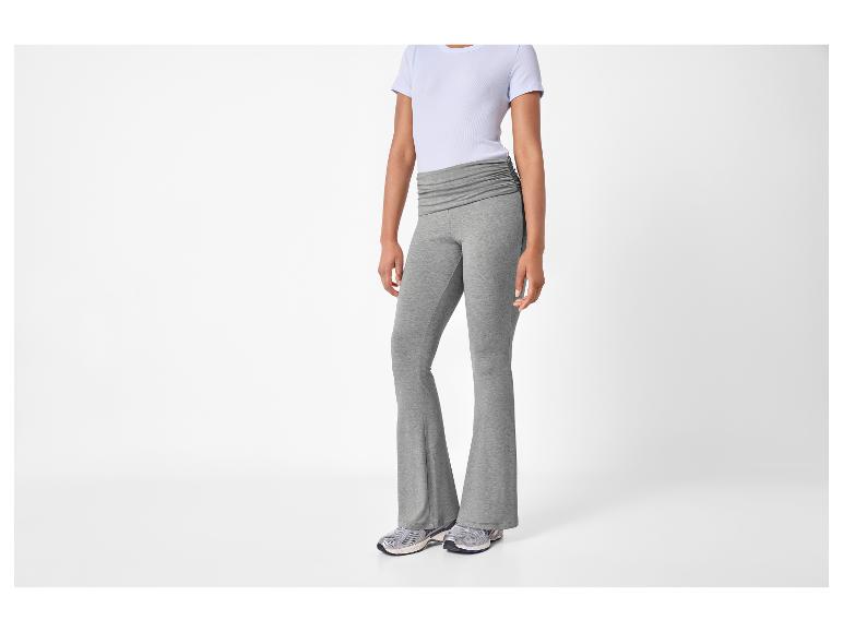 Vrouw in grijze flared broek en lichtblauw T-shirt