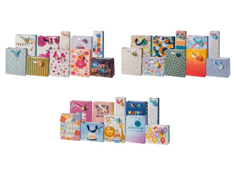 Assortiment kleurrijke cadeauzakjes met diverse patronen en 'Happy Birthday'-berichten.