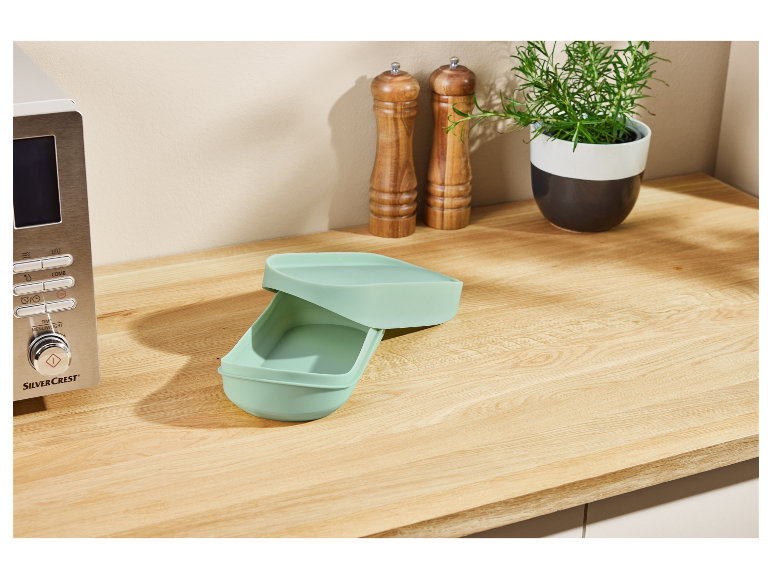 SilverCrest magnetron en lichtgroene siliconen broodtrommel op een houten aanrecht.