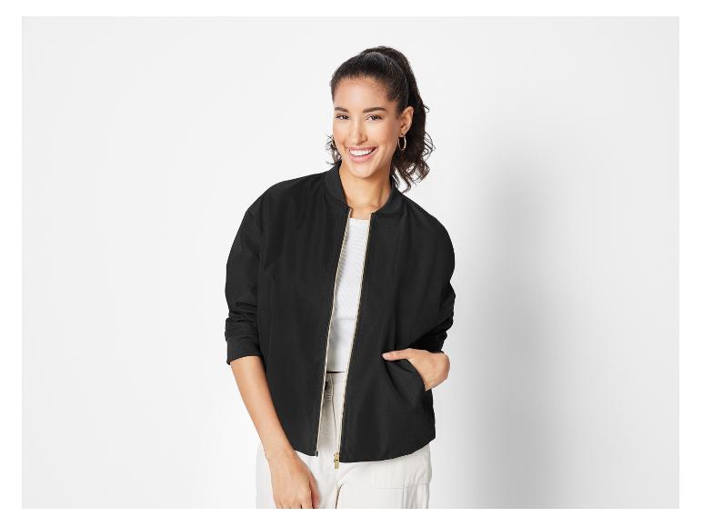 Een vrouw draagt een zwarte bomberjack.