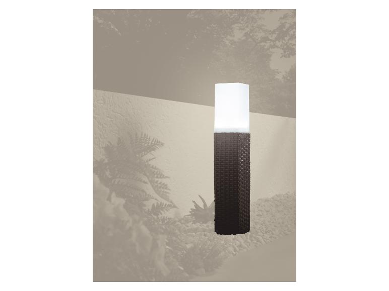 Gevlochten pilaar tuinlamp die een grindpad verlicht.