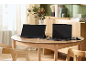 Een draagbare monitor en een laptop aangesloten op een houten tafel in een lichte kamer.