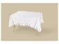Wit tafelkleed met ruches op een houten tafel tegen een beige achtergrond