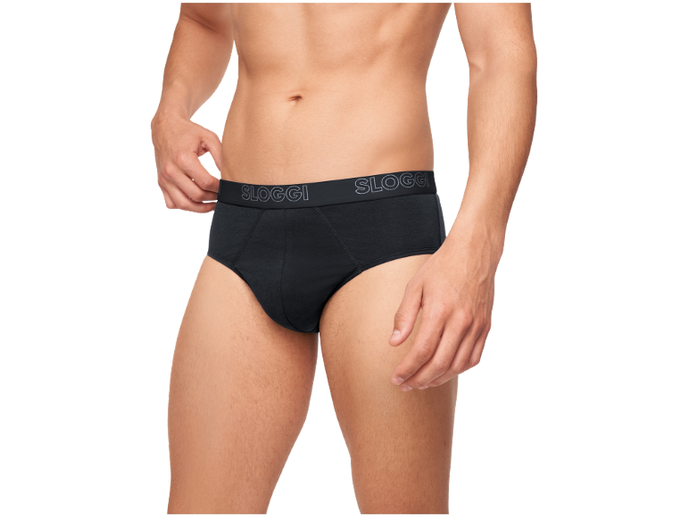 Man in zwarte slip, past de tailleband aan met zijn hand.