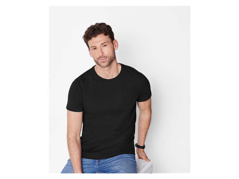 Aantrekkelijke man in zwart t-shirt en jeans.