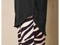 Een zwart overhemd met lange mouwen over een broek met zebraprint.