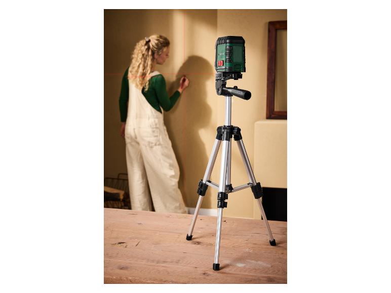 Vrouw markeert muur met Parkside laserwaterpas op statief.