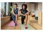 Man en vrouw in sportkleding doen lunges op yogamatten.
