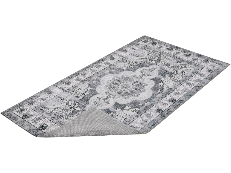 Grijs vloerkleed met bloemenpatroon en centraal medaillon, met de antislip achterkant zichtbaar.