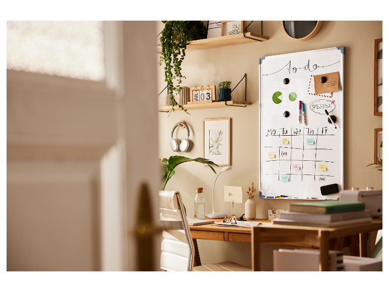 Wit bord, georganiseerde bureau met planten en koptelefoon.