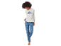 Vrouw in wit shirt met lange mouwen met 'Stitch'-afbeelding en blauwe pyjamabroek met patroon.