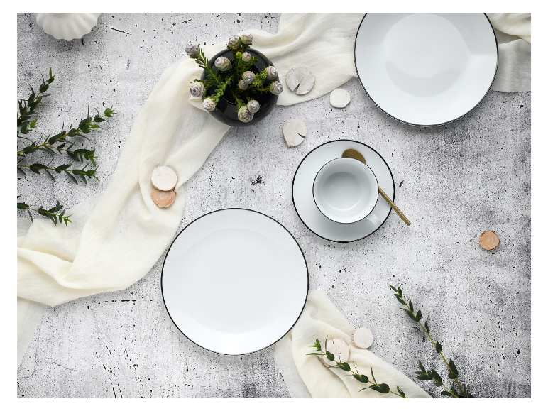 Wit serviesgoed, kop en schotel, minimalistische decoratie.