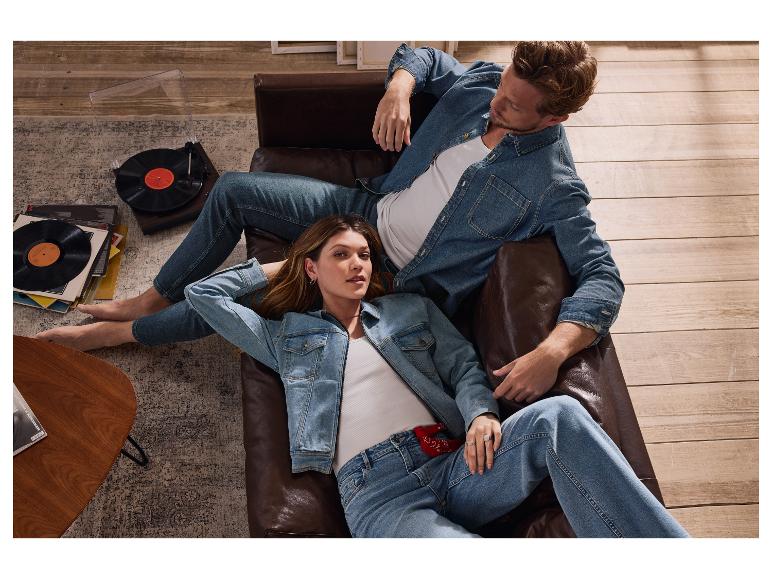 Koppel ontspant op leren bank in jeans.