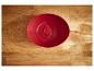 Een rode kom op een houten oppervlak.