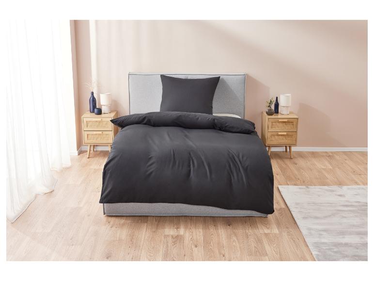 Een zwarte dekbedovertrek op een grijs bed.